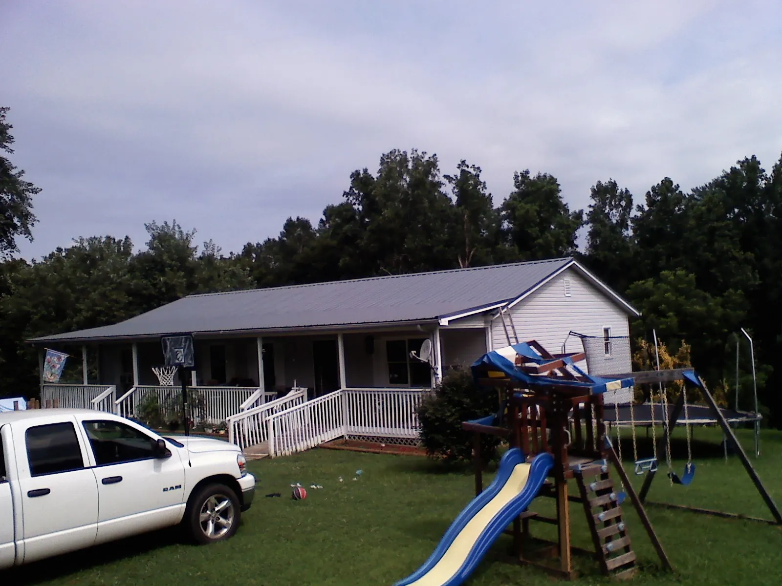 Dark metal roof on a country home with a full length front porch in Bearcreek